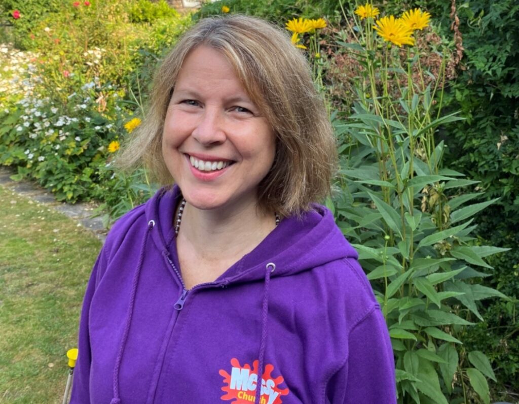 A picture of Aike wearing a purple Messy Church hoodie